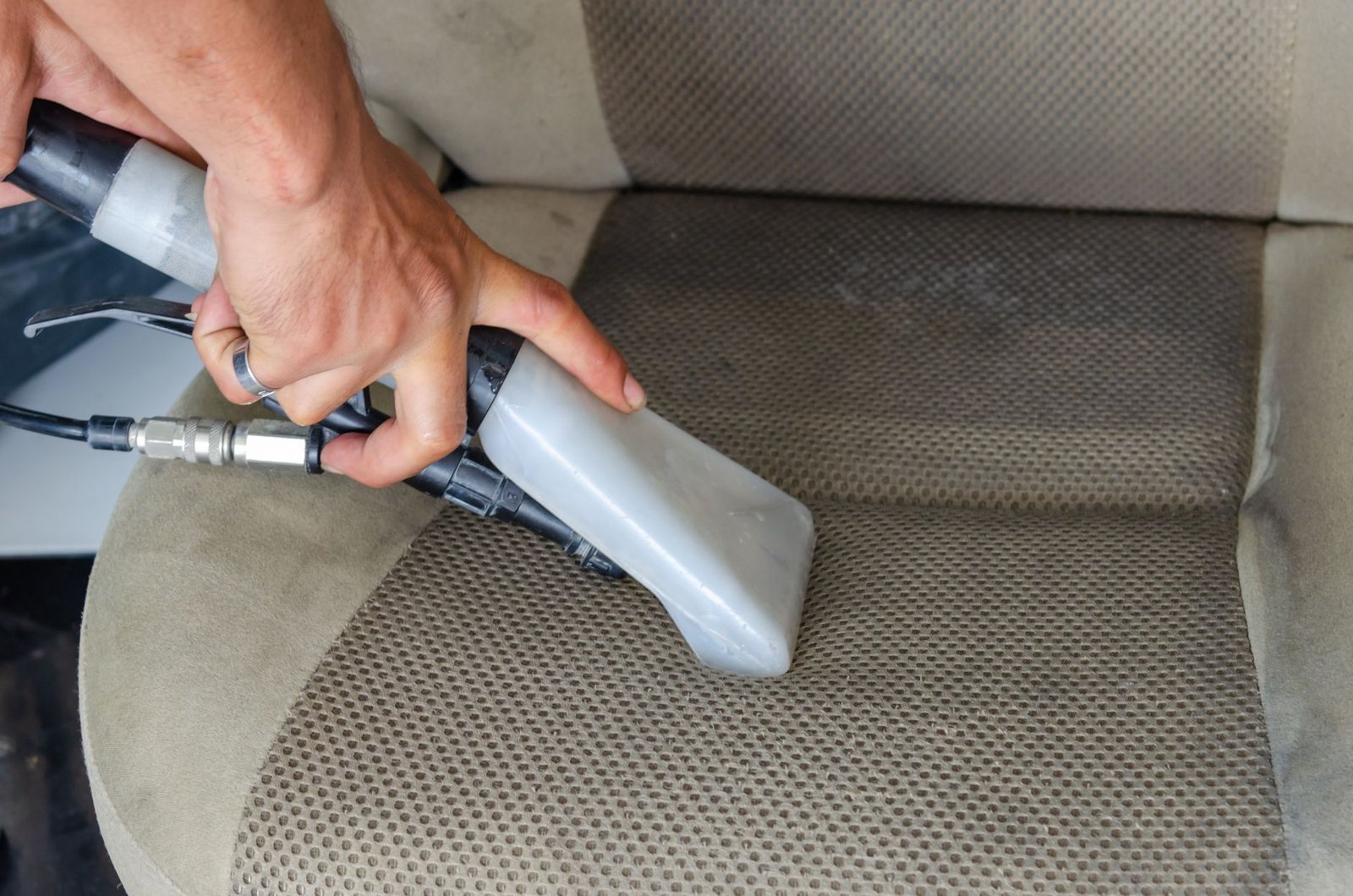 mejor aspirador de mano — limpiando la tapicería del coche